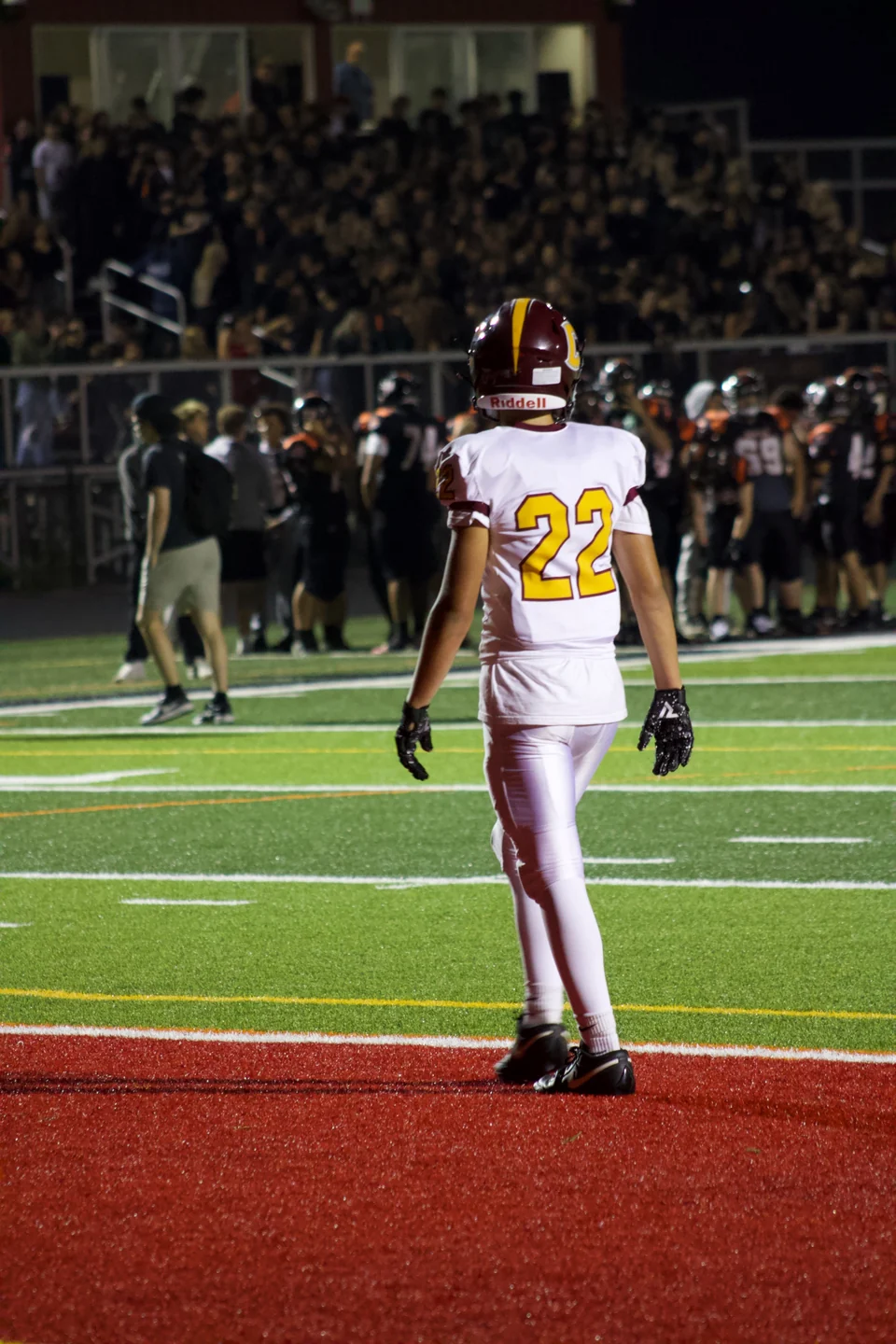 Number 22 on the football field, with the crowd behind him