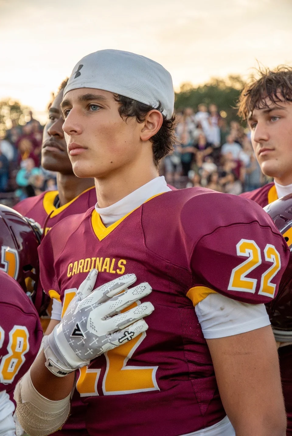 Logan Gadbois wearing his maroon number 22 jersey and a backward white cap, with his hand over his chest.