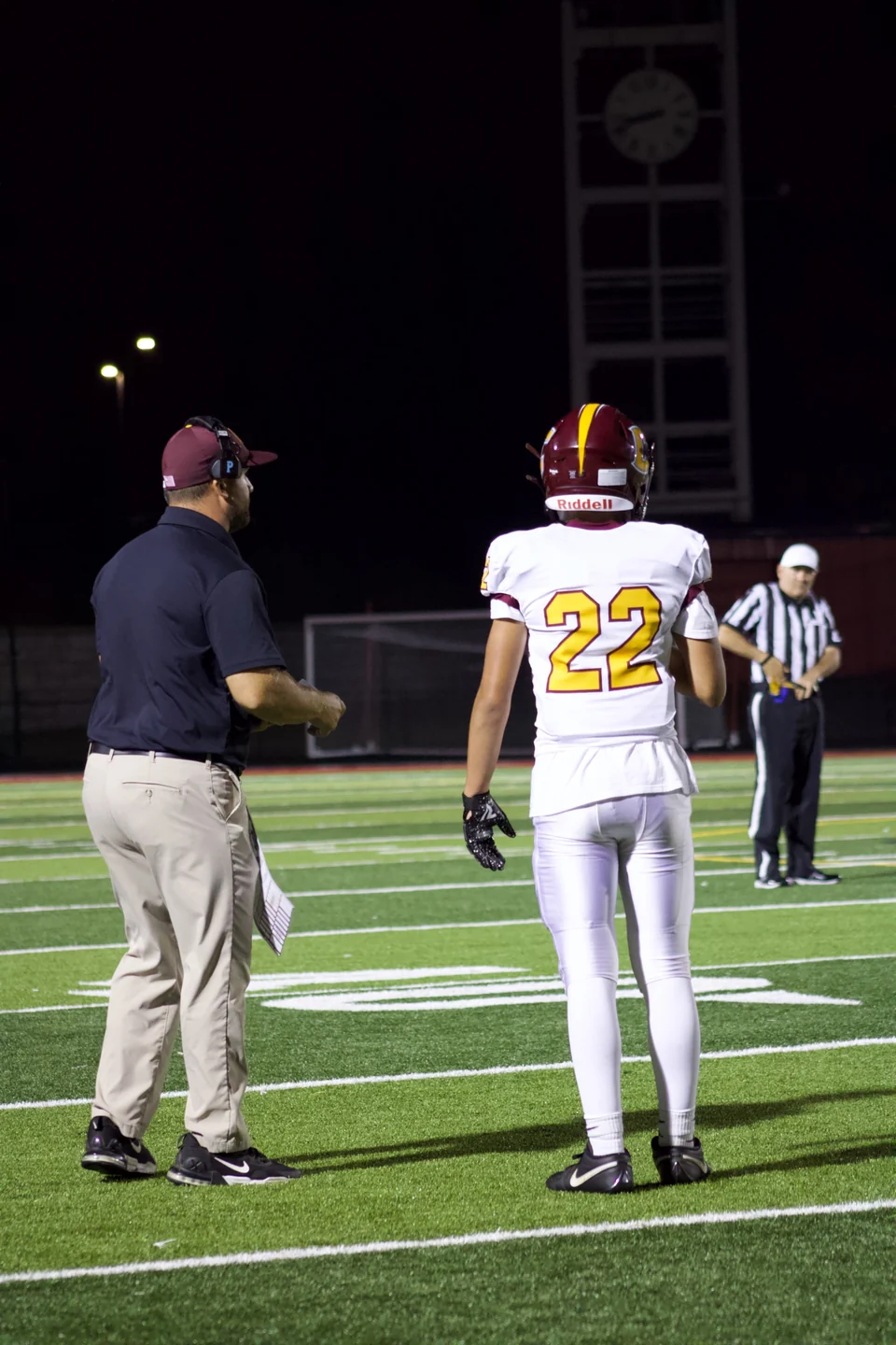 Number 22 standing beside a coach on the field